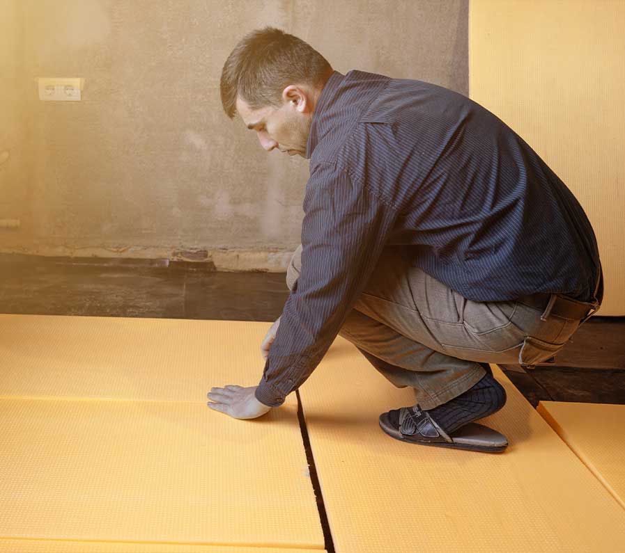 man fitting floor insulation